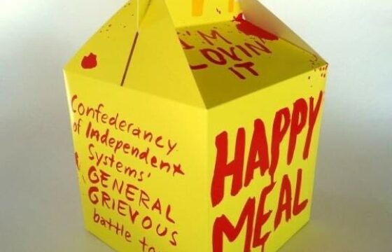 McDonaldsin Happy Meal laatikko, jossa on punaista tekstiä.